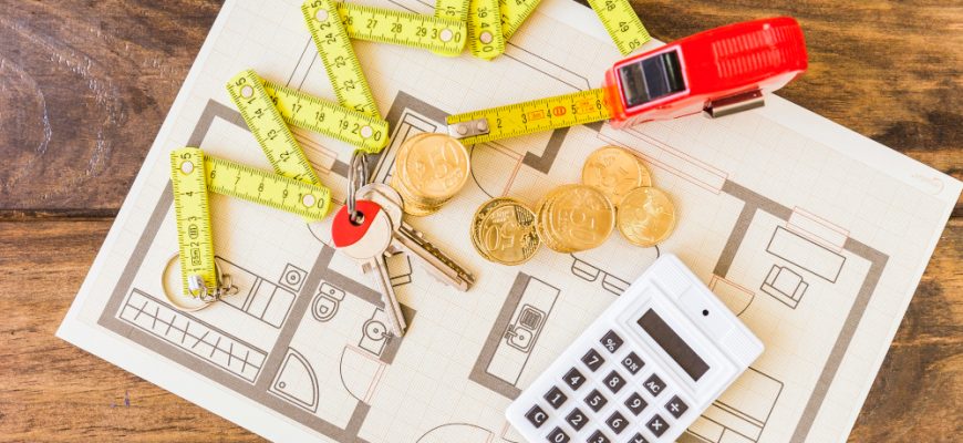 elevated view measure tape stacked coins key calculator blueprint