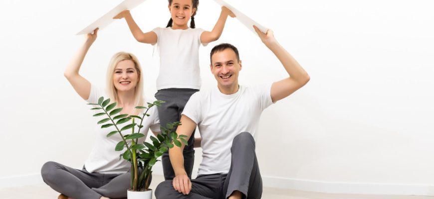 happy family sitting together making home sign