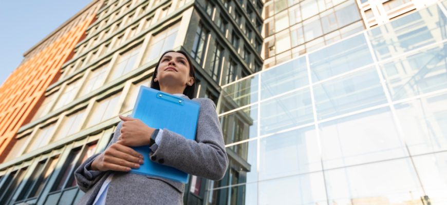 low angle businesswoman holding clipboard city